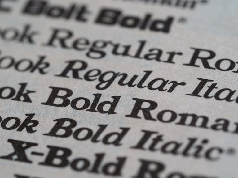 Vue détaillée de polices serif et expérimentales imprimées sur papier, illustrant l'évolution de la typographie et son impact sur l'identité de marque.